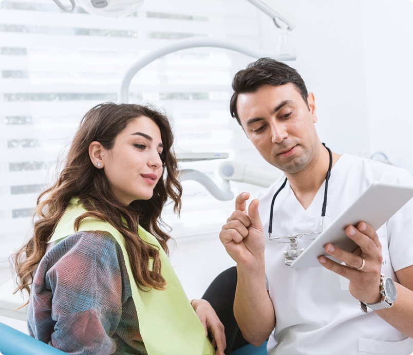 Dentist showing a patient something on a tablet